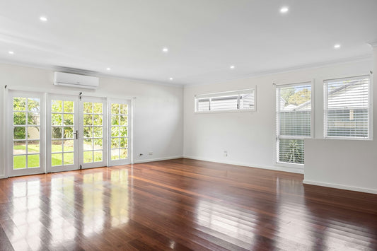 Wall-mounted mini-split heat pump in a bright living room with hardwood floors — what to look for in a mini-split before buying in 2026