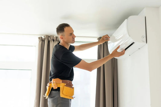 Homeowner mounting the indoor head of a DIY mini-split on an interior wall